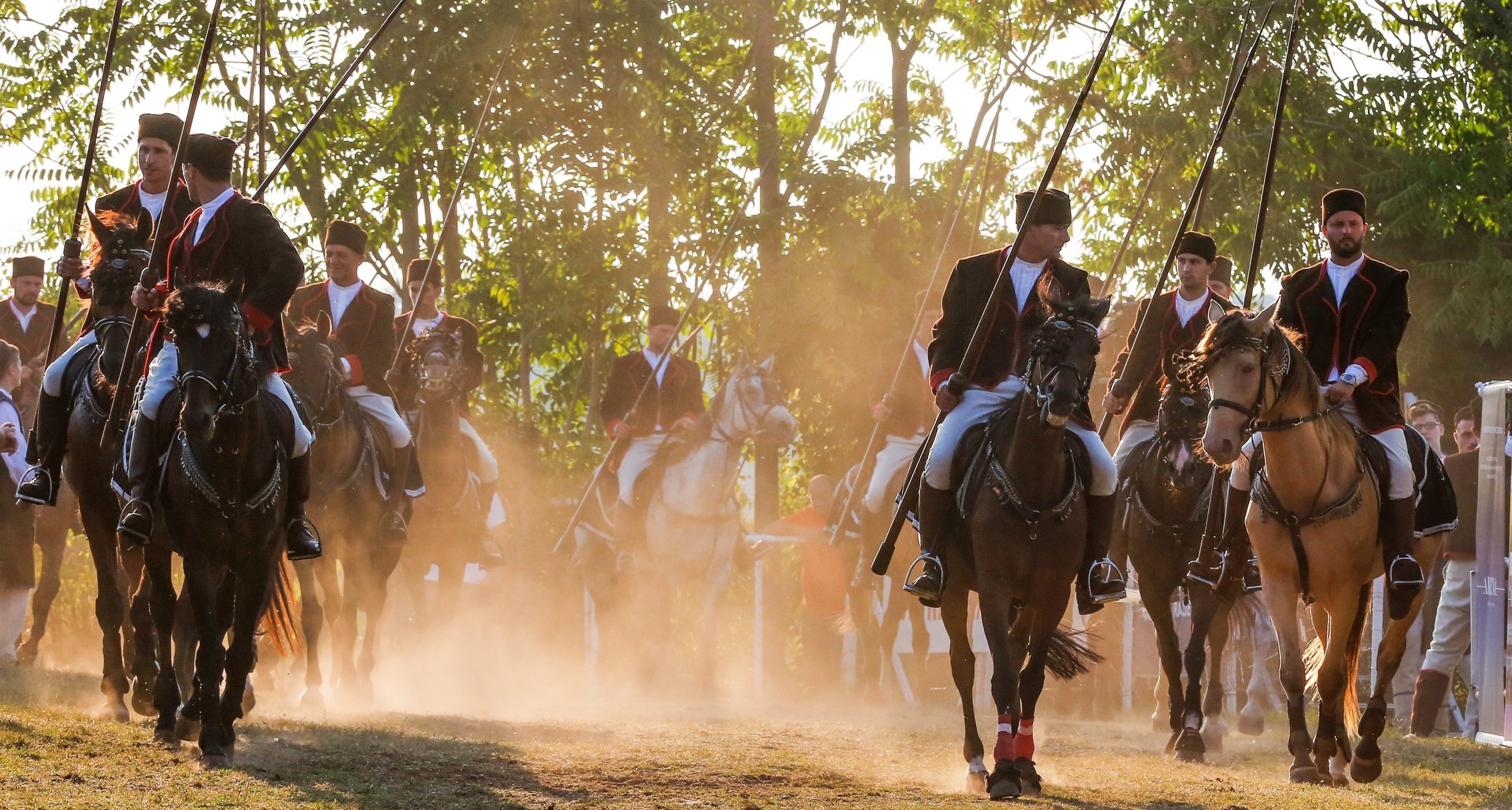 Traditional horse race "Trka na prstenac" in Barban, featuring riders in historical costumes galloping on horseback through the dust.
