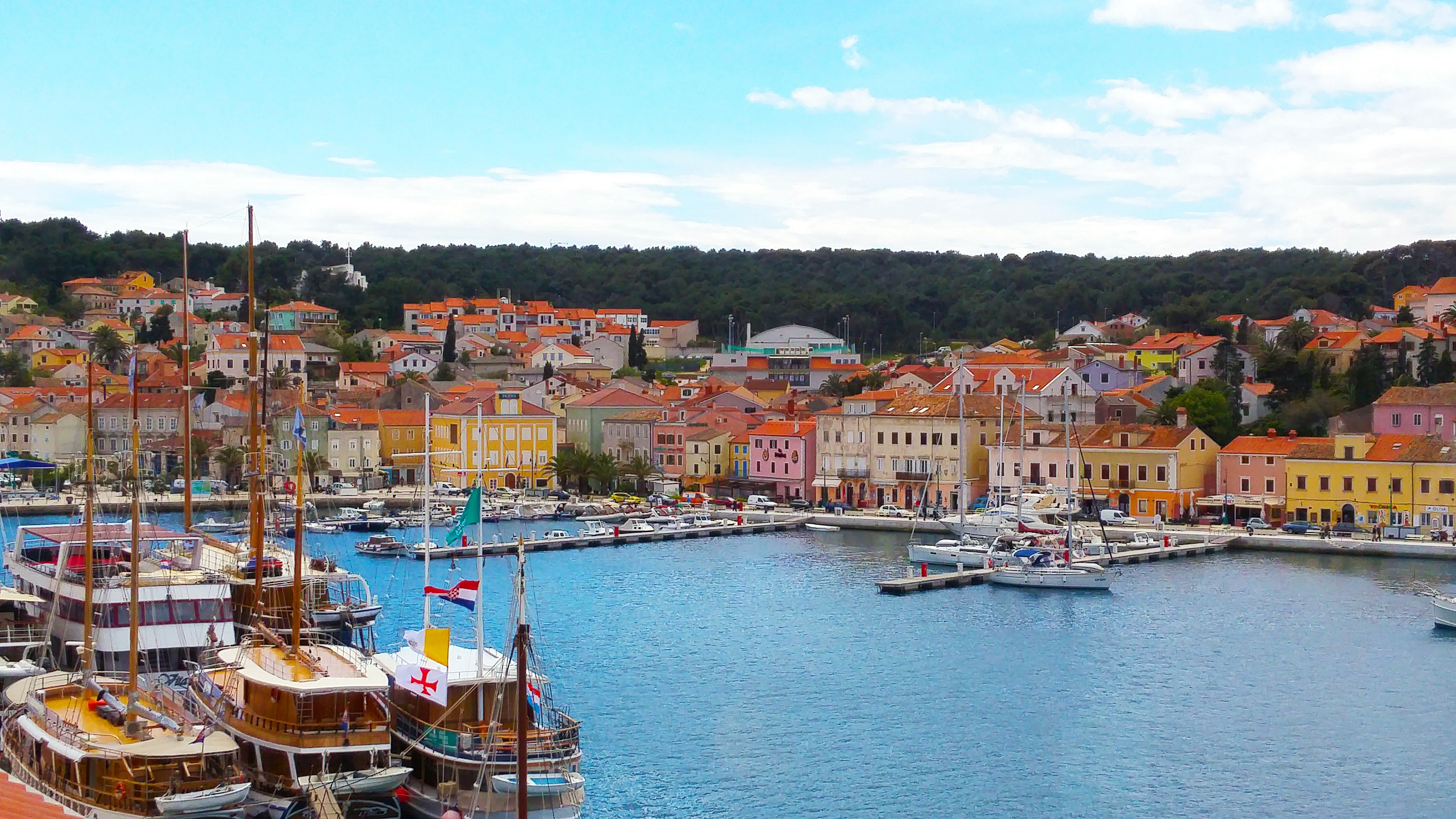 Port Mali Lošinj z tradycyjnymi łodziami, jachtami i kolorowymi nadbrzeżnymi domami na wyspie Lošinj w Chorwacji