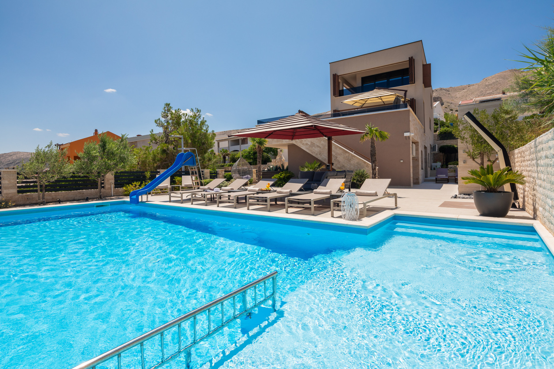Moderna villa di lusso Villa Emma sull'isola di Pag con ampia piscina privata, scivolo d'acqua, lettini prendisole e vista panoramica sull'Adriatico.