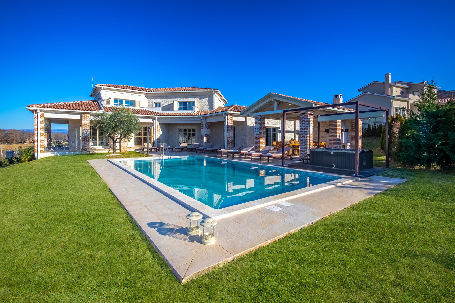 Villa Star Istria featuring a private swimming pool, spacious terrace with sun loungers, covered outdoor dining area and a landscaped garden with Mediterranean greenery.