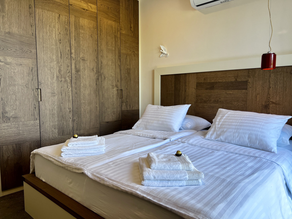 Moderna camera da letto en-suite presso Villa Signature Krk, con ampi armadi in legno, un comodo letto matrimoniale e un design d'interni accogliente.