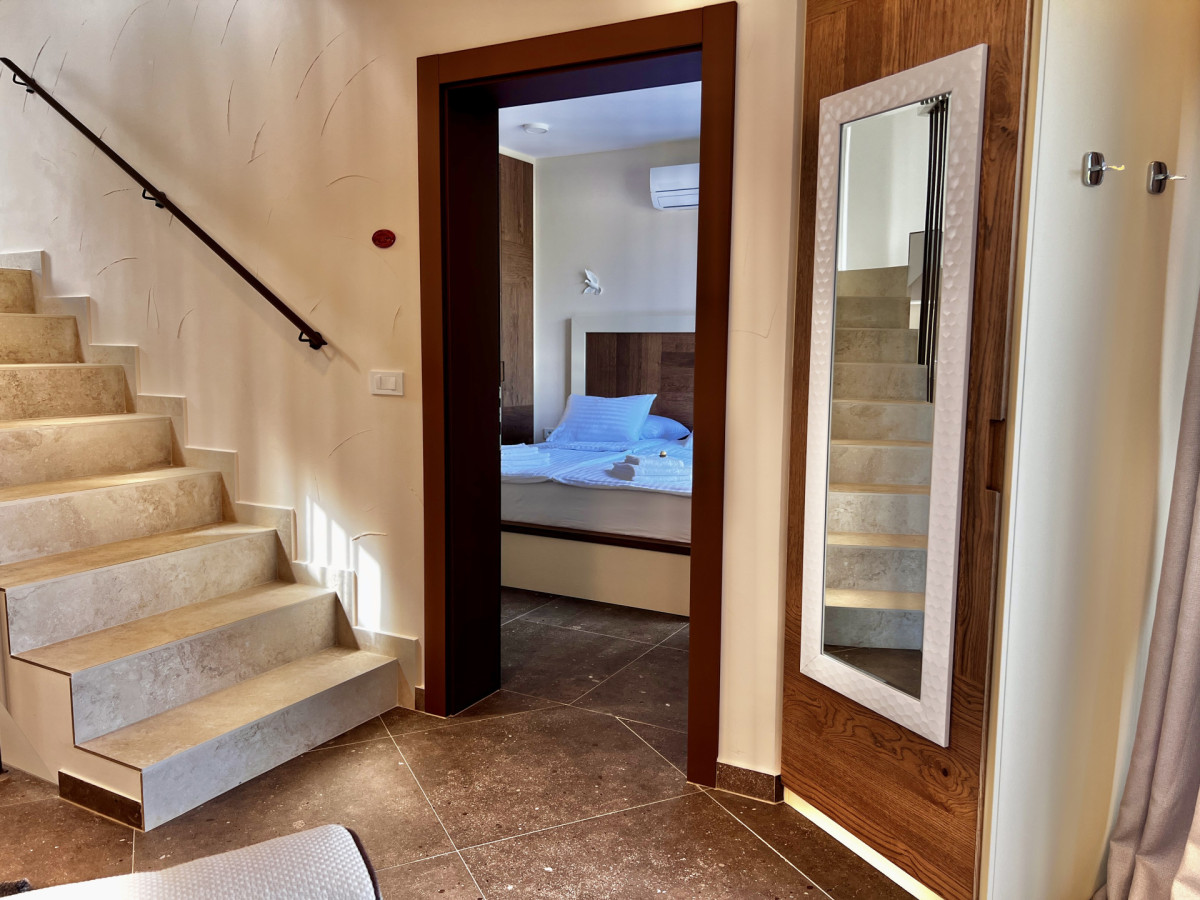 Moderno corridoio presso Villa Signature Krk con eleganti scale in pietra e una vista accogliente sulla camera da letto.