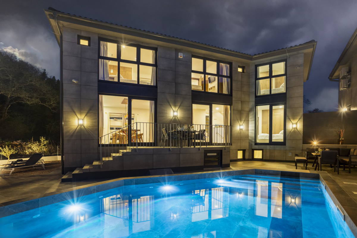 Villa Signature Krk di notte con piscina riscaldata illuminata.