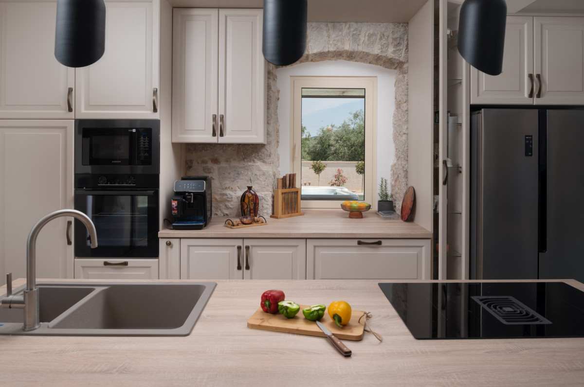 The high-end kitchen of Villa Utopia with premium Samsung built-in ovens and refrigerator, a Philips espresso machine, and a modern induction cooktop