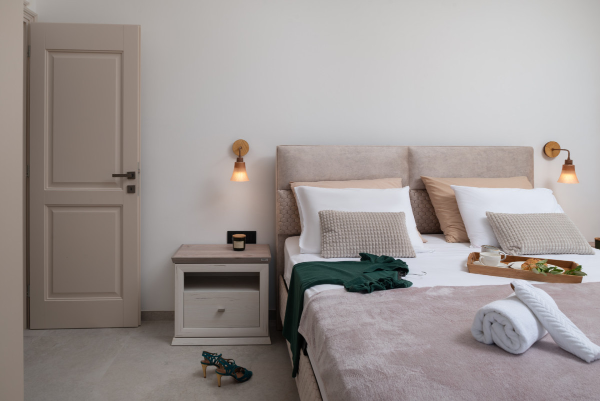 Luxurious bedroom at Villa Utopia with tufted headboard, a minimalist light wood nightstand with a designer lamp