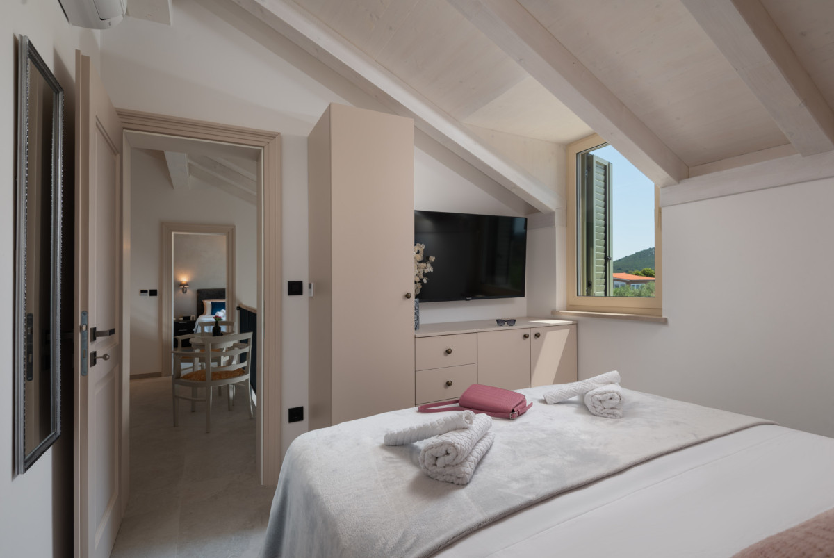 Cozy loft bedroom at Villa Utopia overlooking a natural landscape on Ugljan.