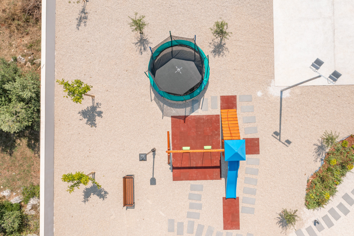 Modern Outdoor Play Area with Safety Mats, Swing and Trampoline