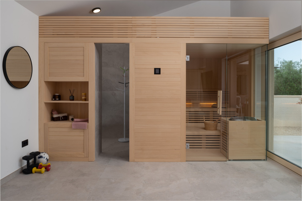Modern home wellness room with custom wood sauna and gym equipment