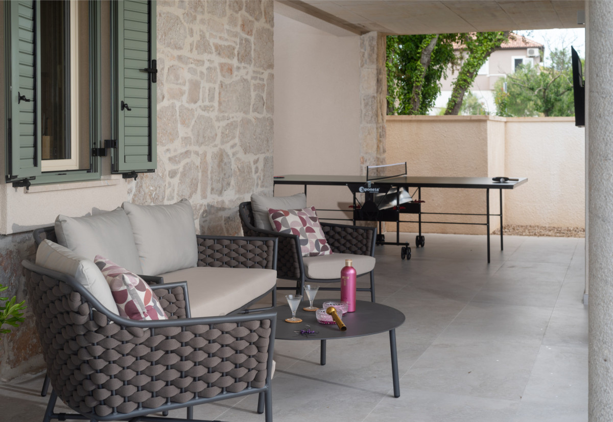 Modern terrace with woven furniture and ping-pong table for family fun