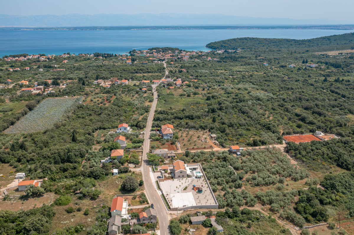 Breathtaking aerial view of Villa Utopia on Ugljan island, showcasing the vast estate, private tennis court, and proximity to the sparkling Adriatic Sea.