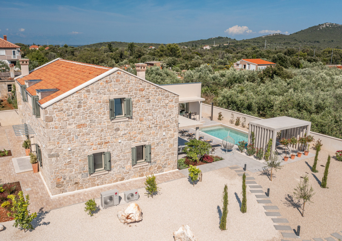 Villa Utopia: A premier stone residence on Ugljan featuring a turquoise pool, sun-drenched lounge, and private gardens nestled in a Mediterranean olive grove.