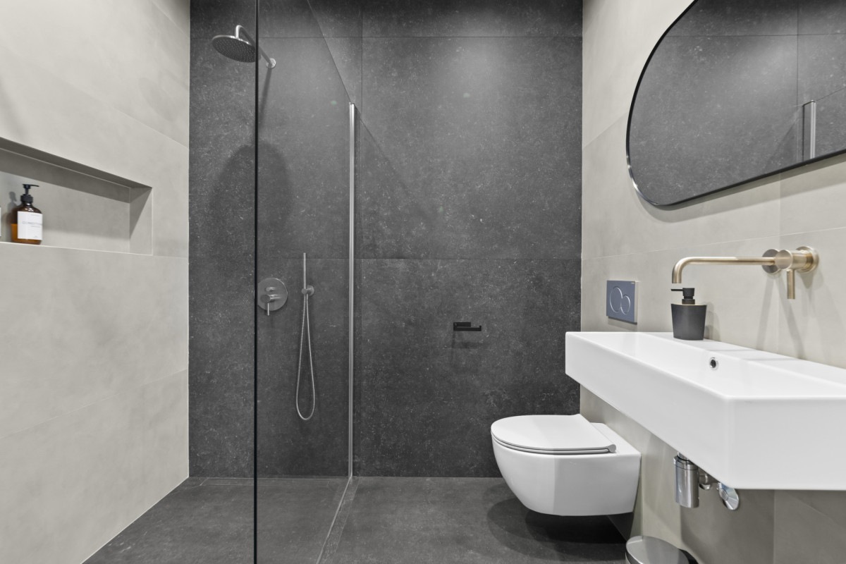 Luxuriöses Badezimmer in der Villa Casa Calme mit goldenen Akzenten und einer begehbaren Dusche.