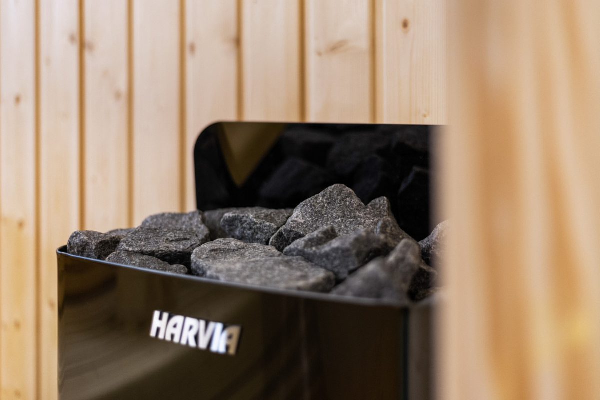Nahaufnahme eines hochwertigen Harvia-Saunaofens mit Vulkansteinen im privaten Wellnessbereich der Villa Casa Calme.