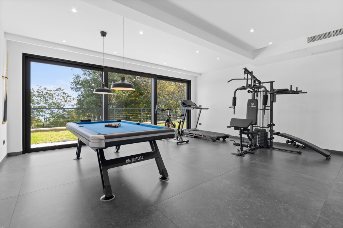 Moderner privater Fitness- und Freizeitraum in der Villa Casa Calme mit einem Billardtisch und einem Laufband.