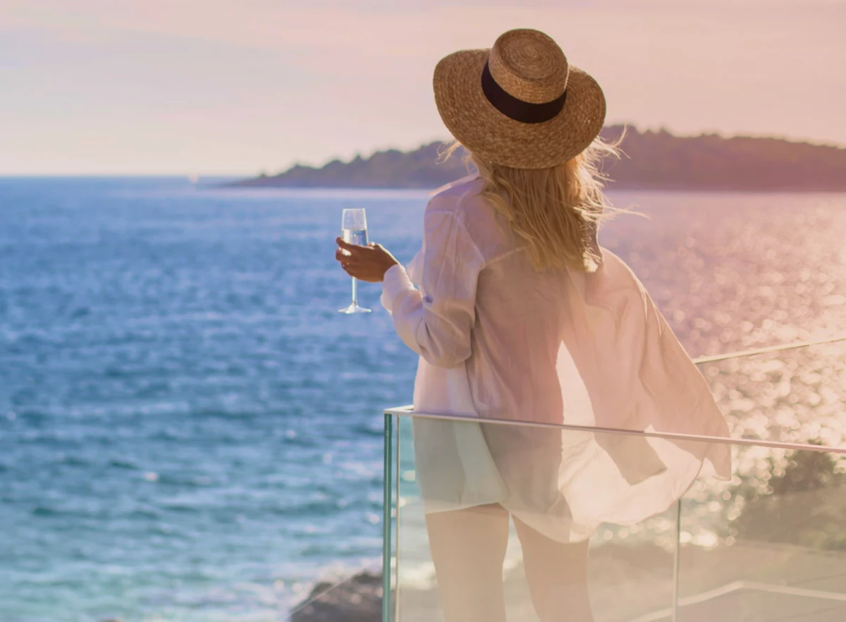 Women loking at Adriatic sea holding wine glass